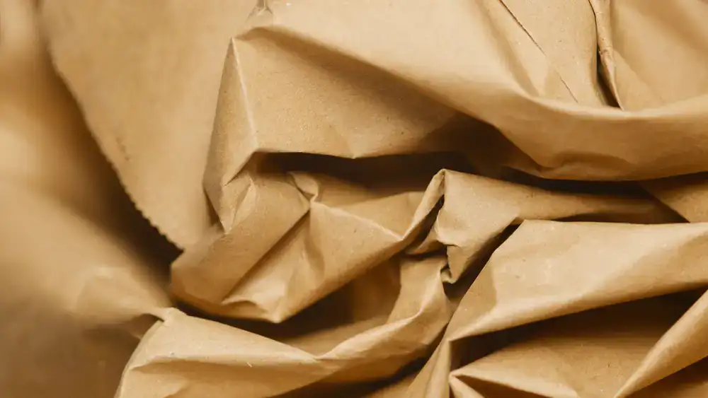 Kraft paper rolls and natural packaging materials stacked in a bright warehouse